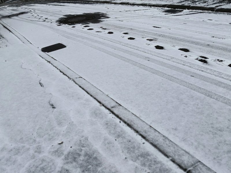 雪が少しだけ積もった自宅前の道路の画像です